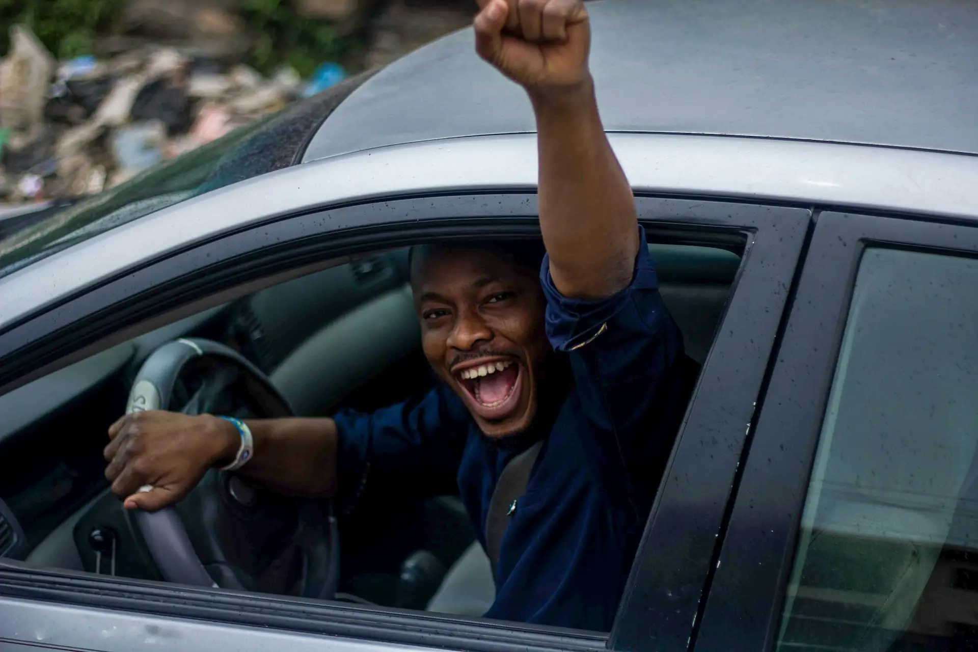 A driver cheering out of his car window