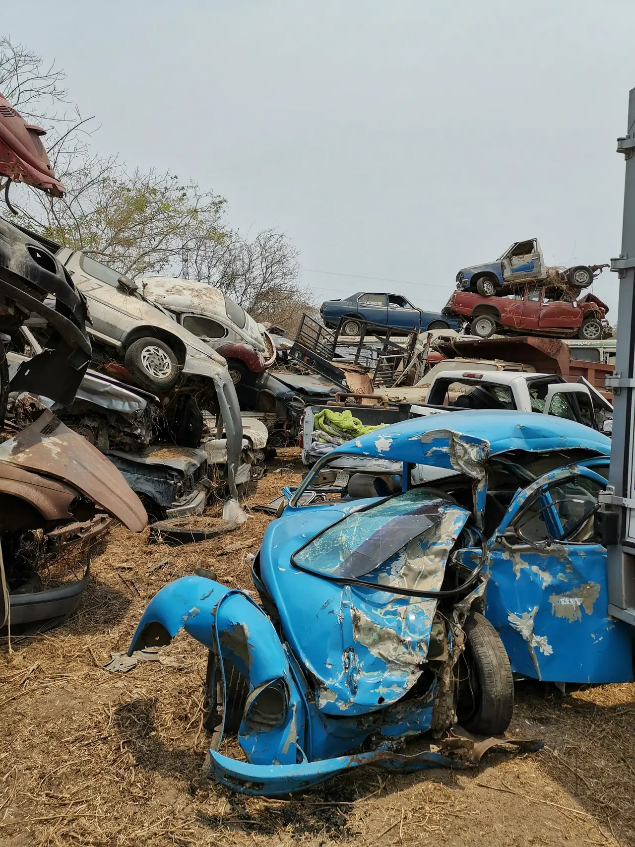 Old cars piled up at a recycling yard