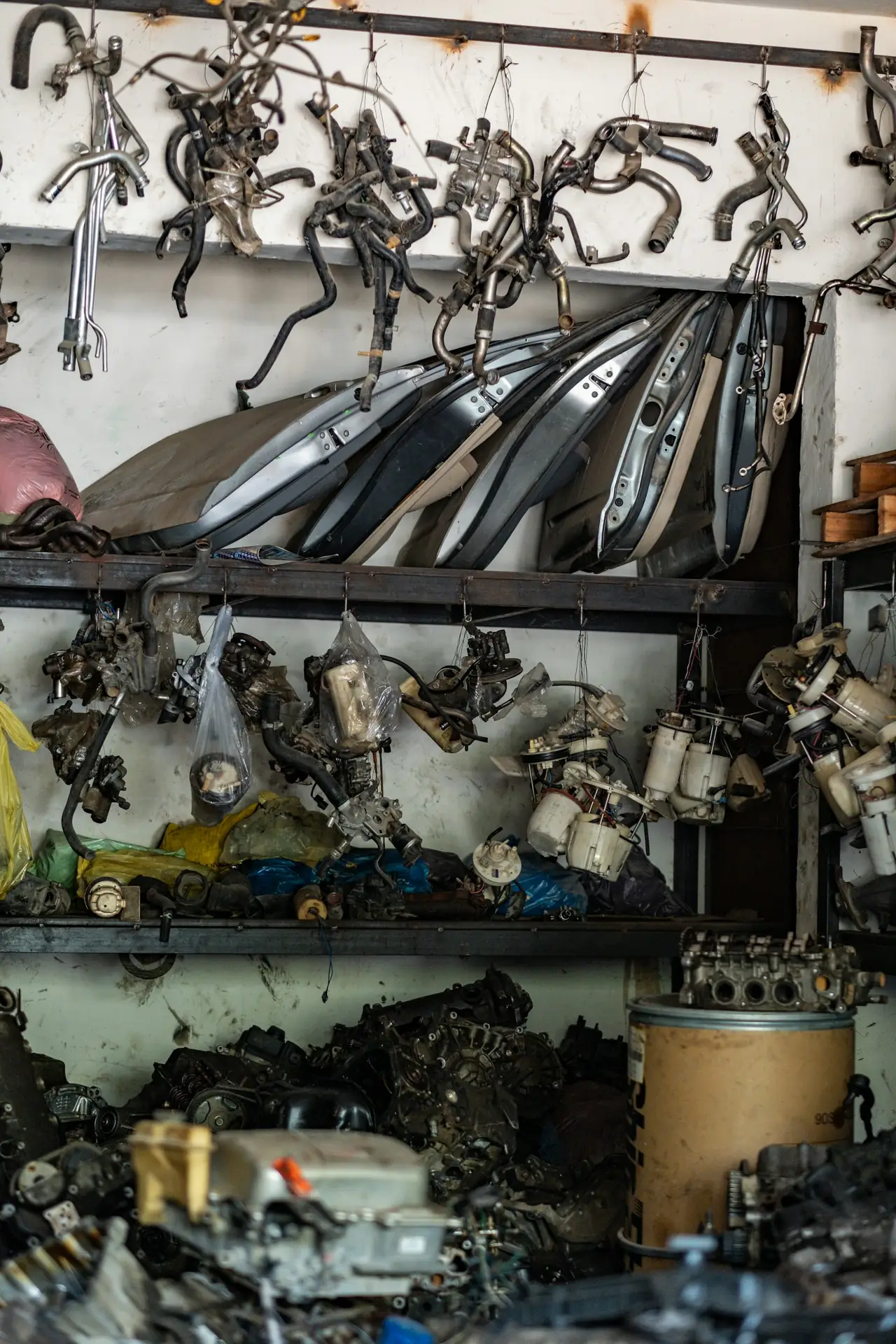 A wall of used car parts at a recycling yard